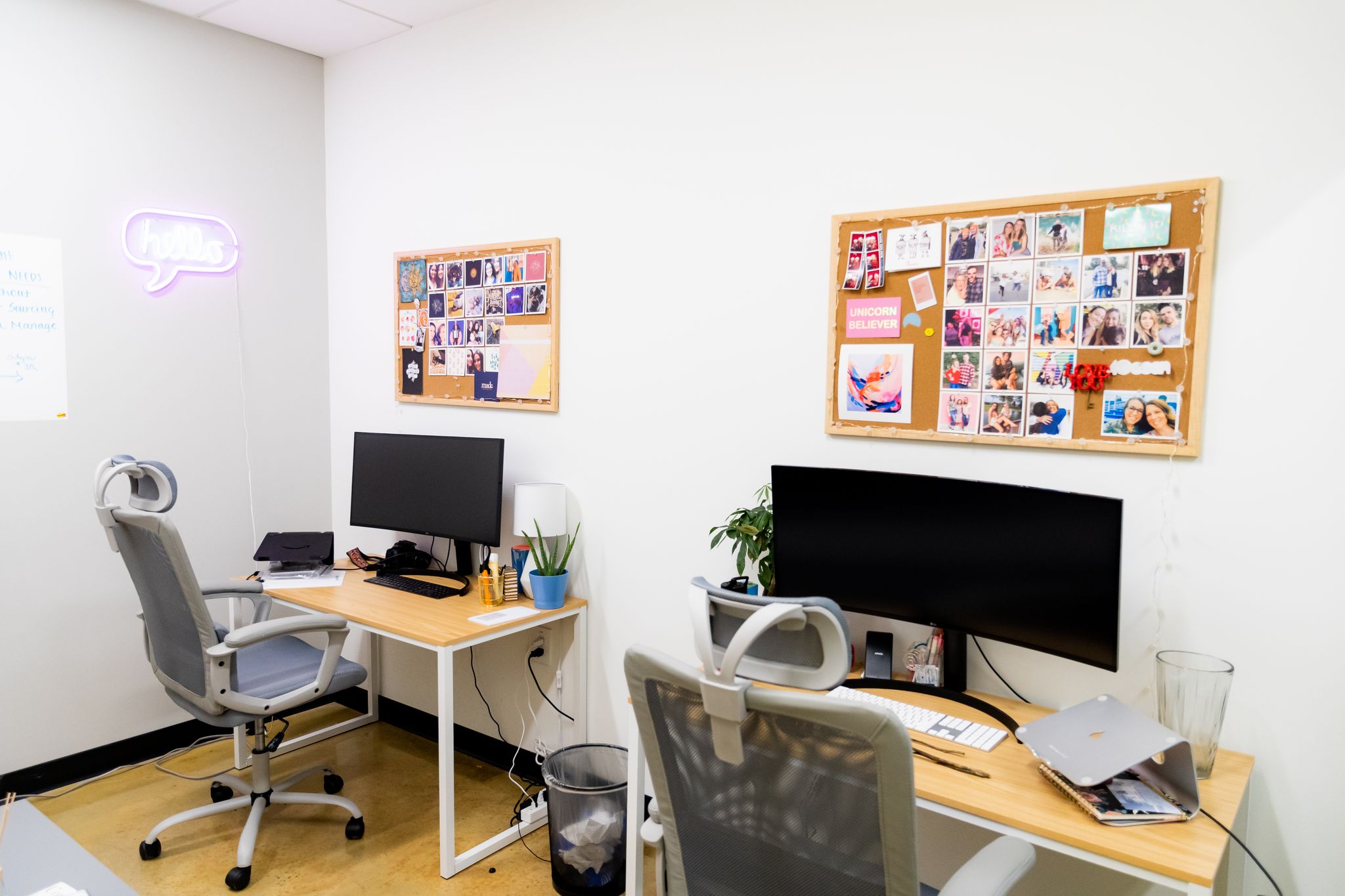 Two desks with monitors and moodboards above them