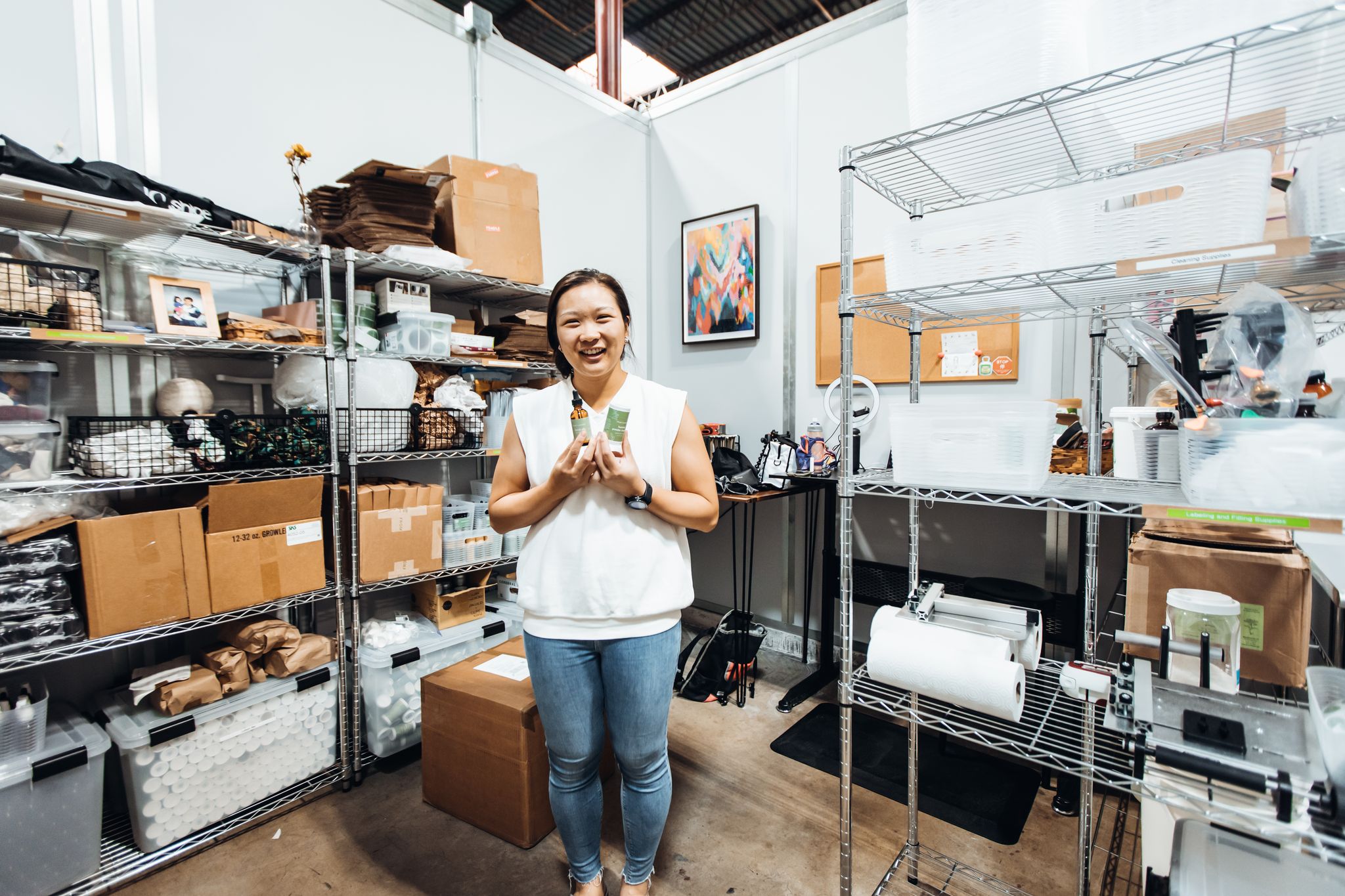 Woman showing bottle products standing in an office/warehouse