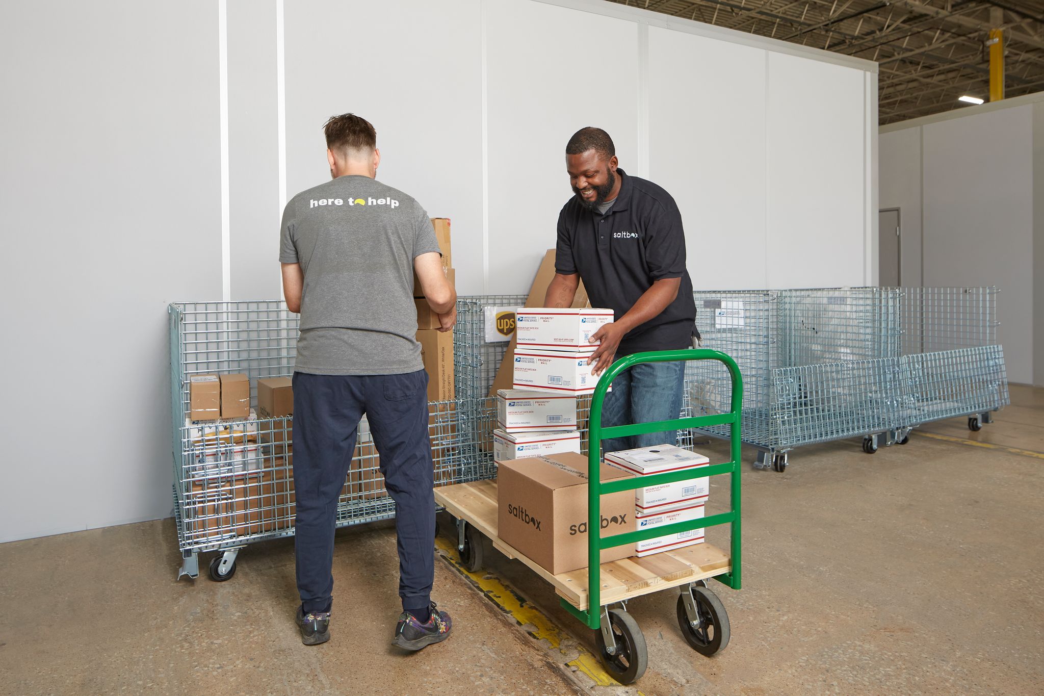 Two men loading boxes in warehouse